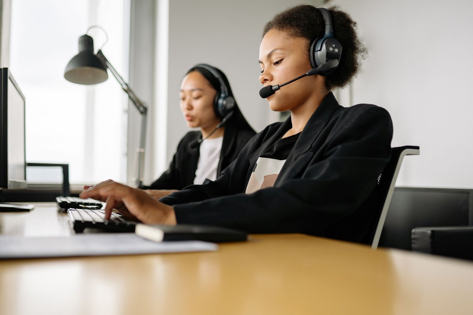 Customer service team wearing headsets working at a modern office